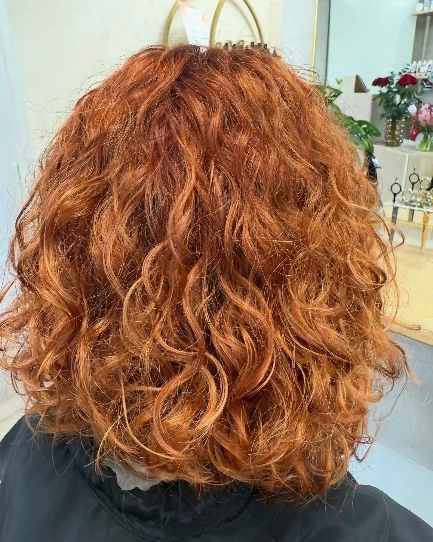 Coloration rousse cuivrée cheveux bouclés mi-longs